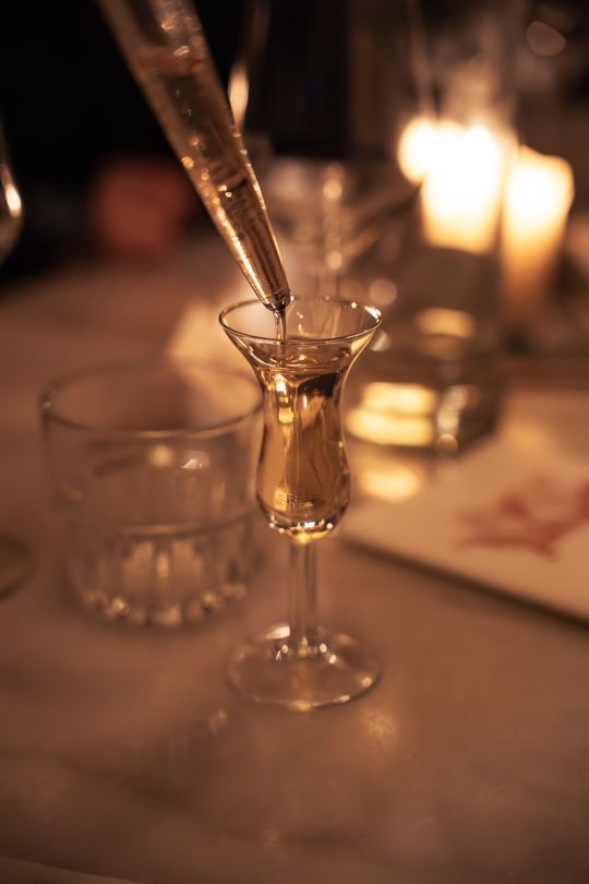 Wentelteefjes liqueur being poured by candlelight